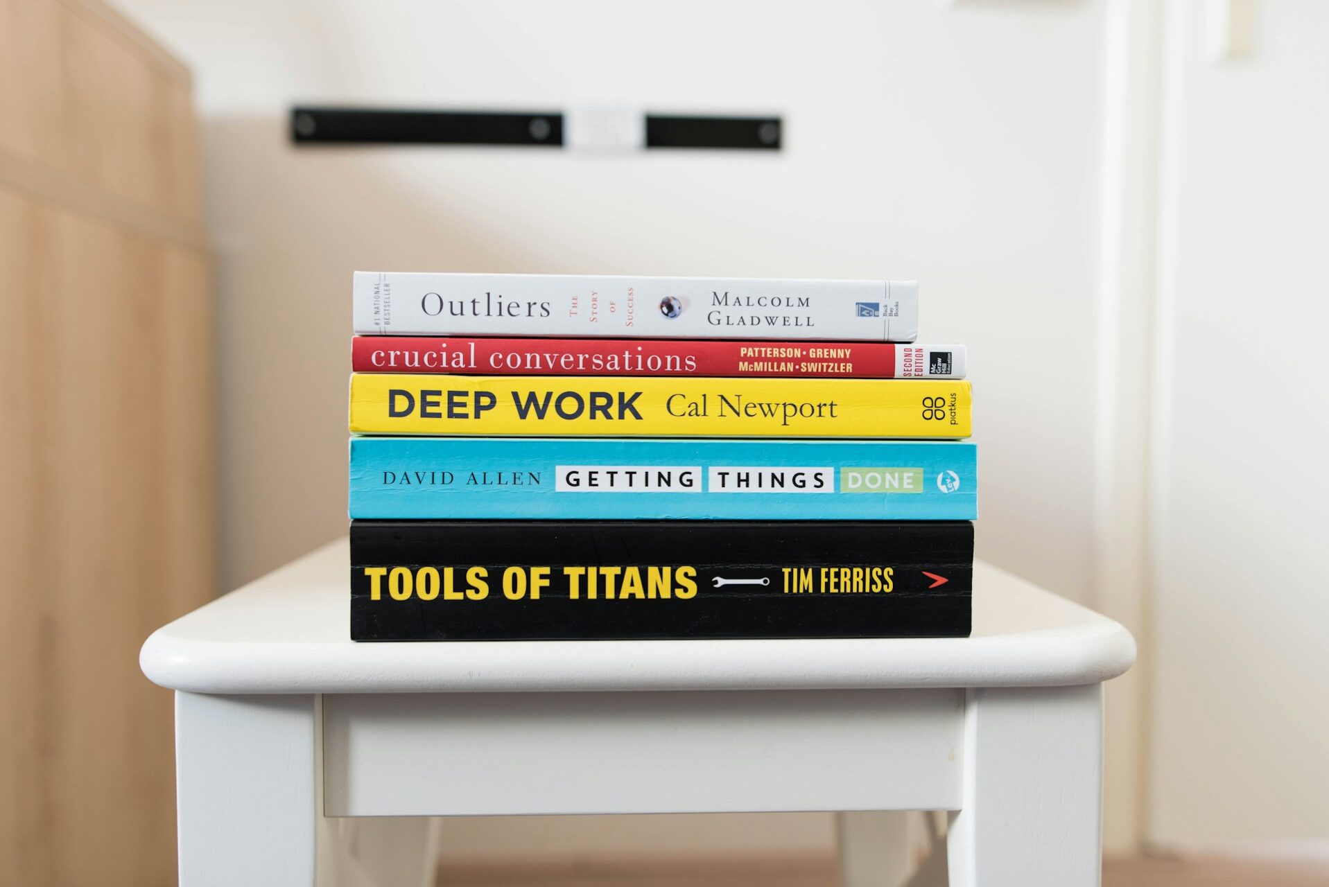 libros de autoayuda en inglés apilados sobre una mesa de madera