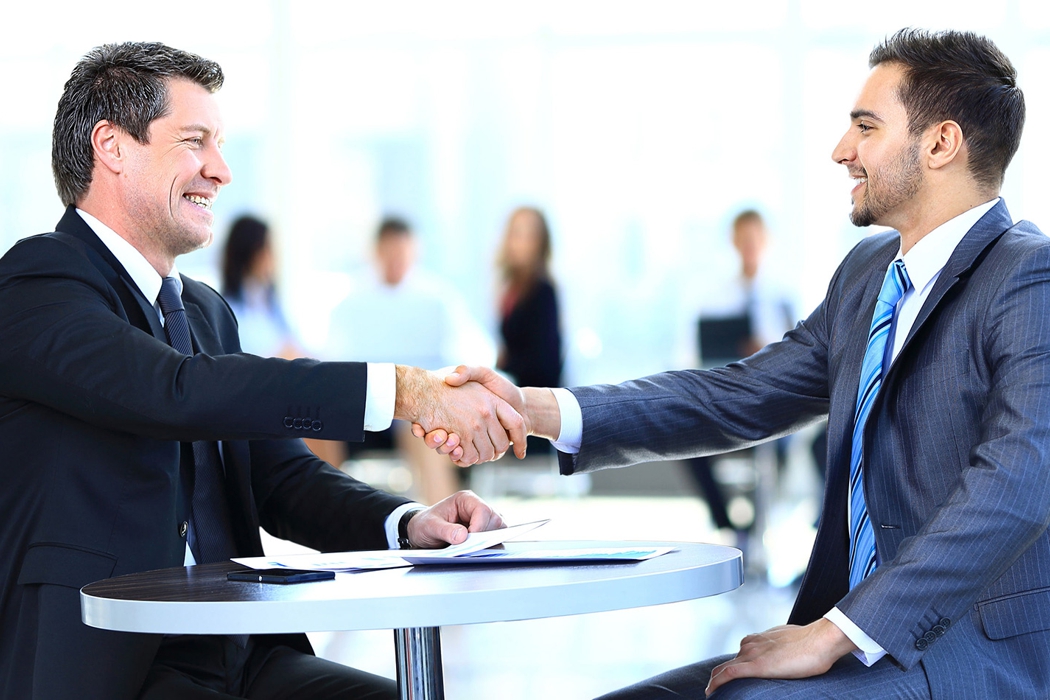 Dos personas dándose la mano tras cerrar un acuerdo comercial